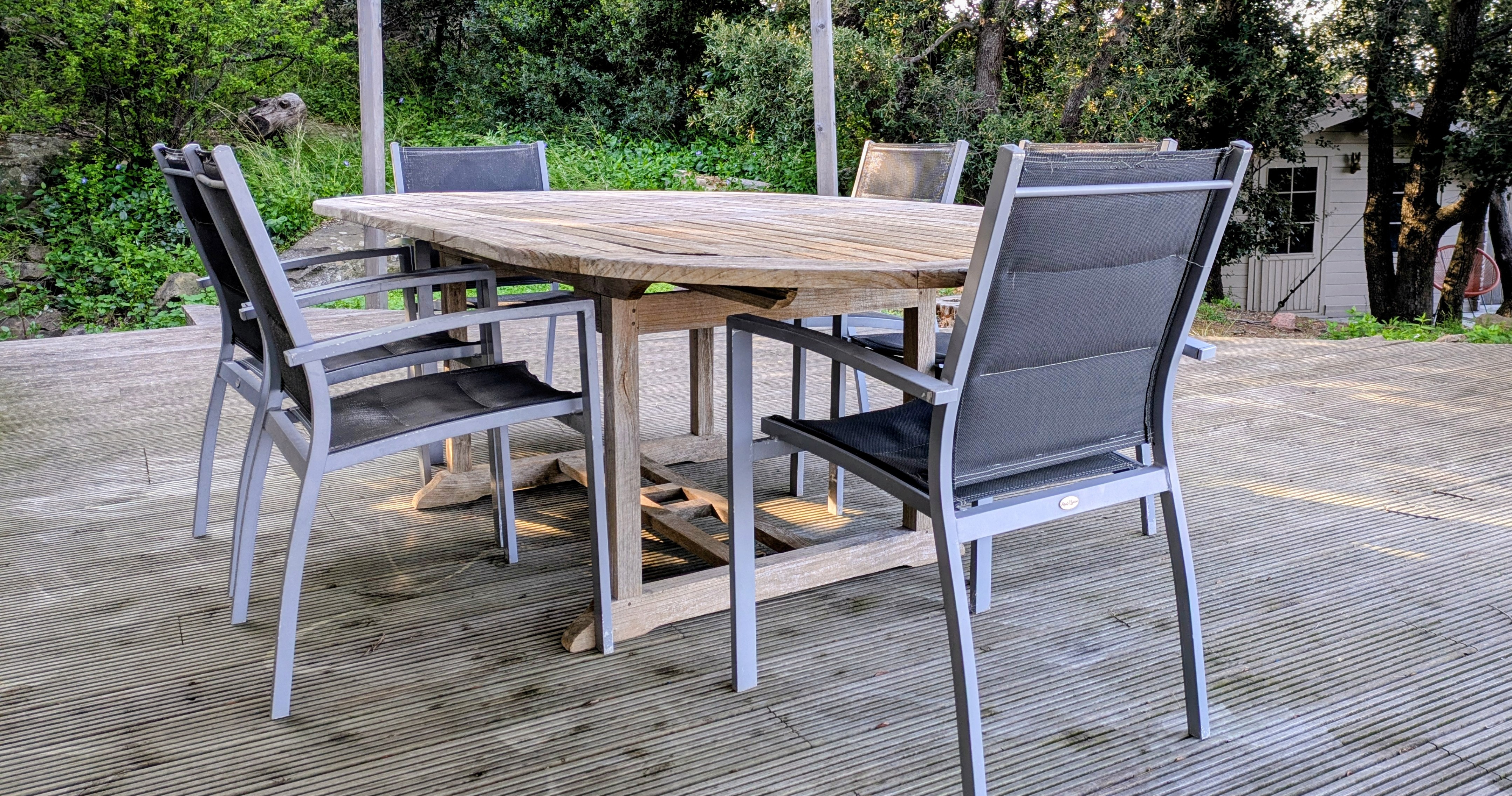 Espace repas extérieur sur la terrasse en bois au cœur du jardin