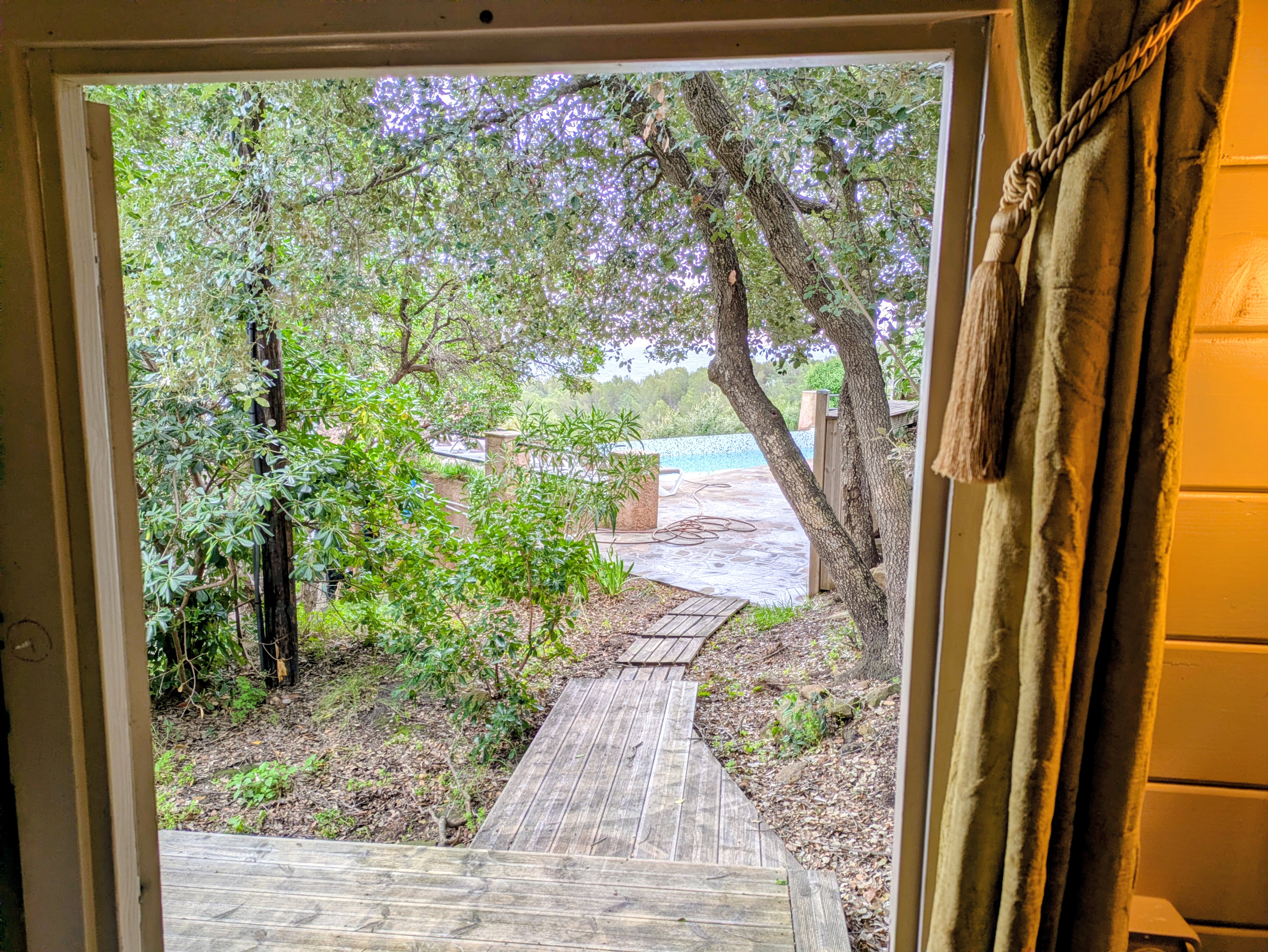 Vue sur le jardin arboré depuis la chambre Cabane