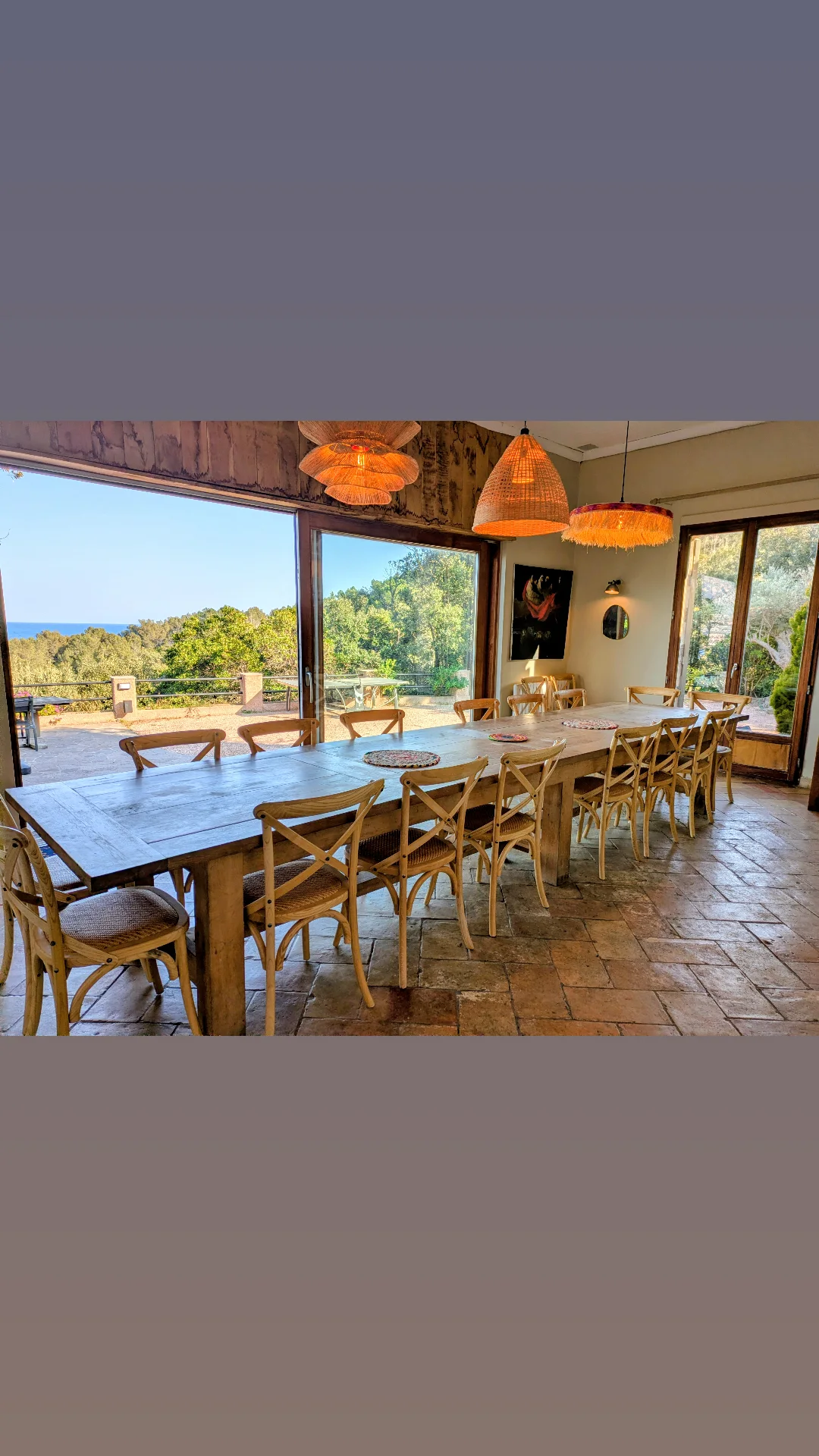 Grande table de séjour ouverte sur la terrasse et la piscine