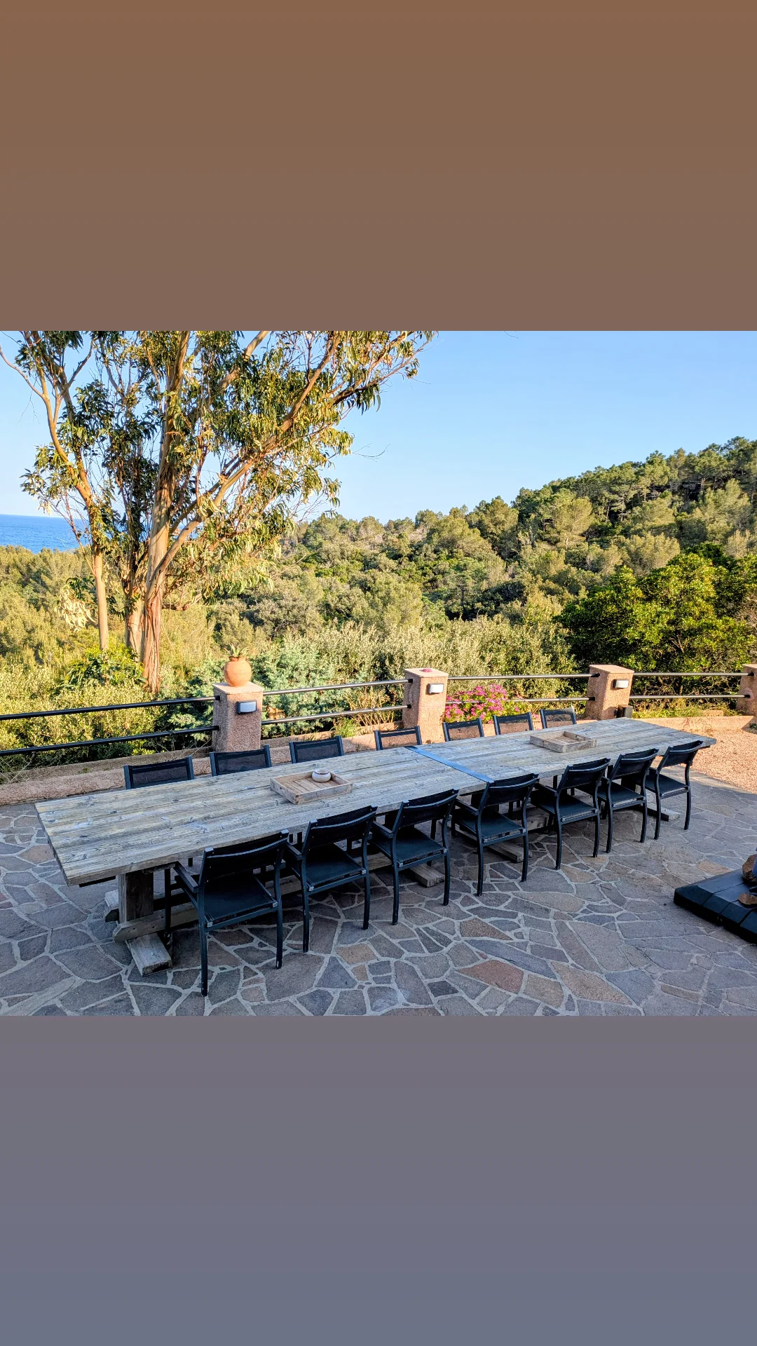 Grande table extérieure sur la terrasse en pierre face aux collines