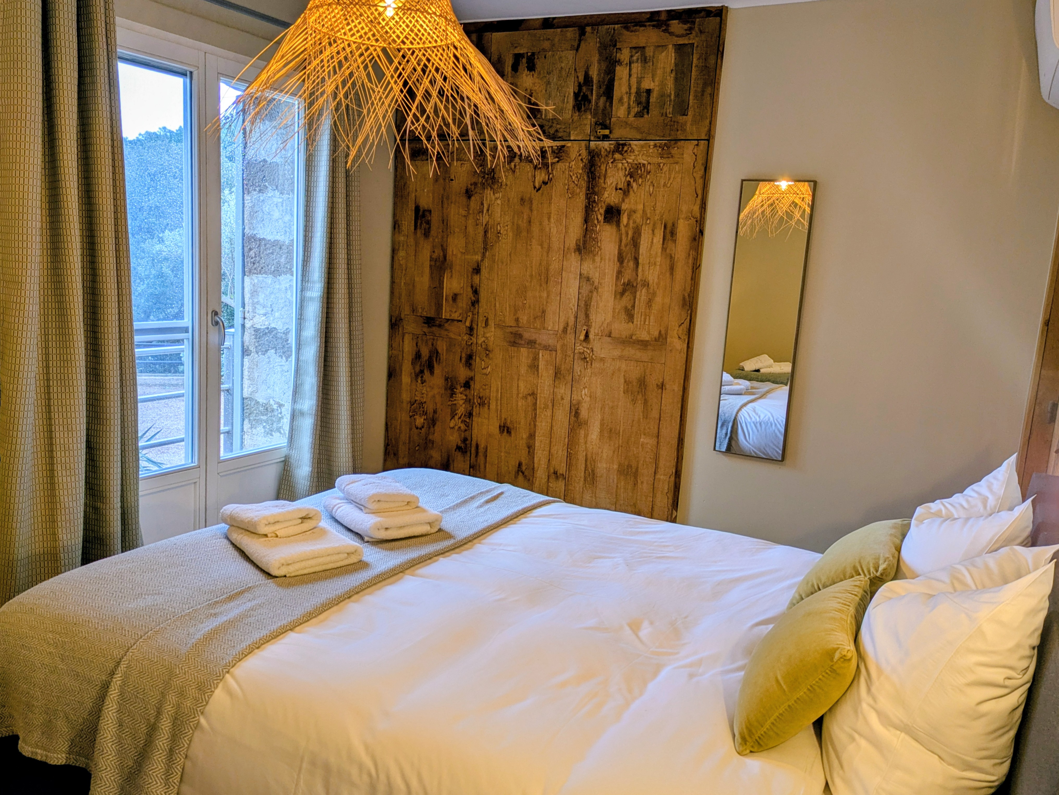 Chambre 3 personnes avec mobilier en bois et vue sur les collines