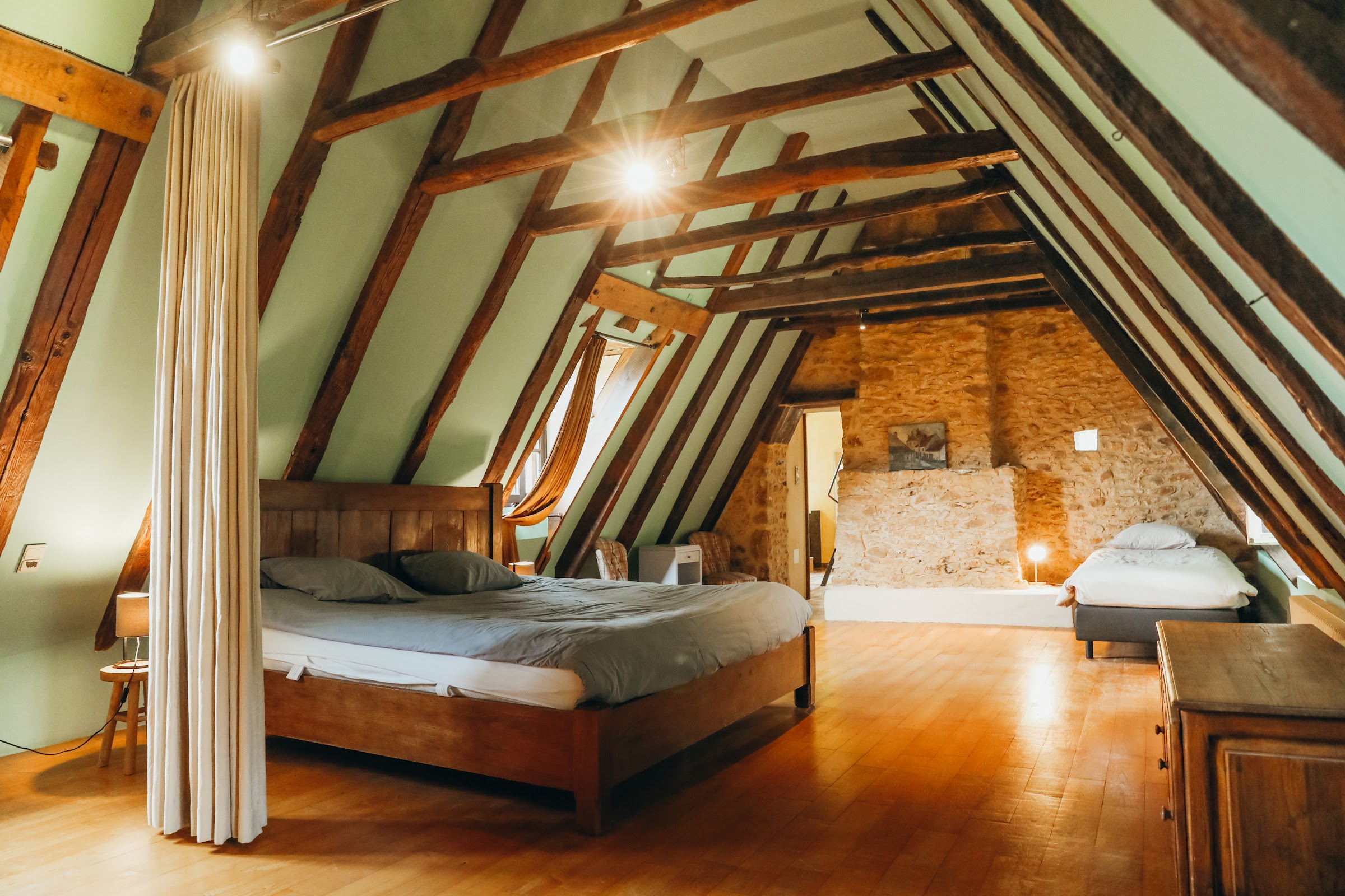 Chambre sous charpente aux murs de pierre