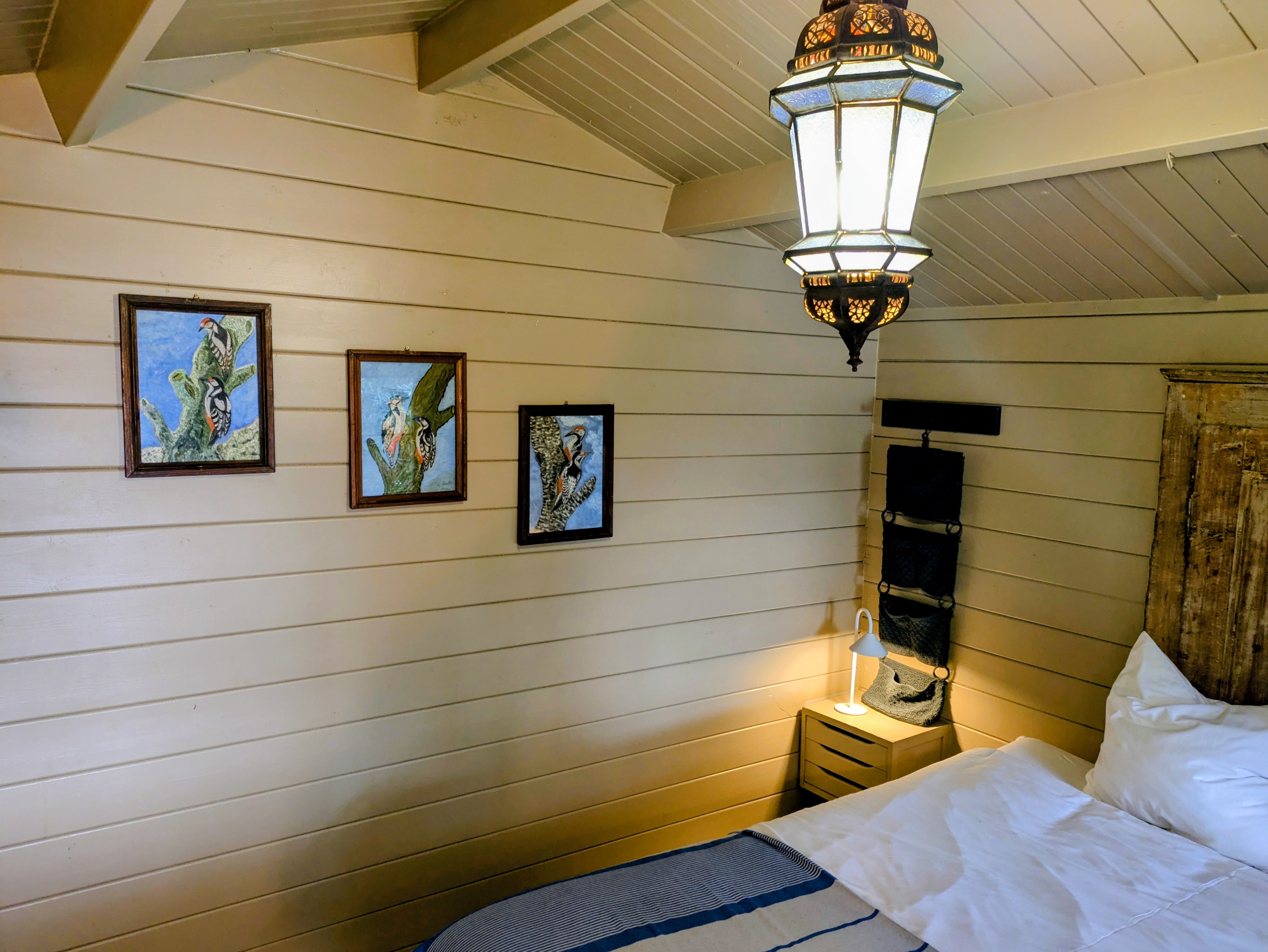 Chambre Cabane aux murs de bois clair et décor coloré