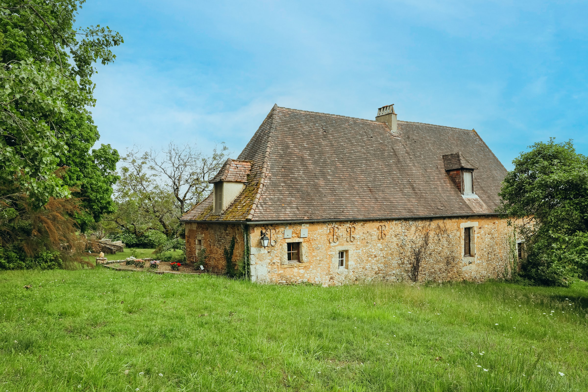 Maison de pierre au milieu de la prairie